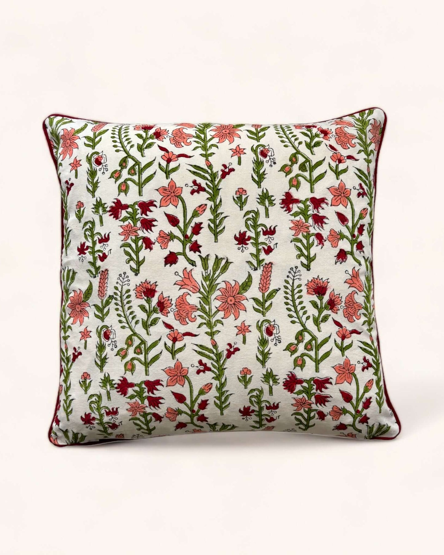 Cuscino decorativo 40x40 cm con design a fiori stampato a mano, retro bianco e bordino rosso.