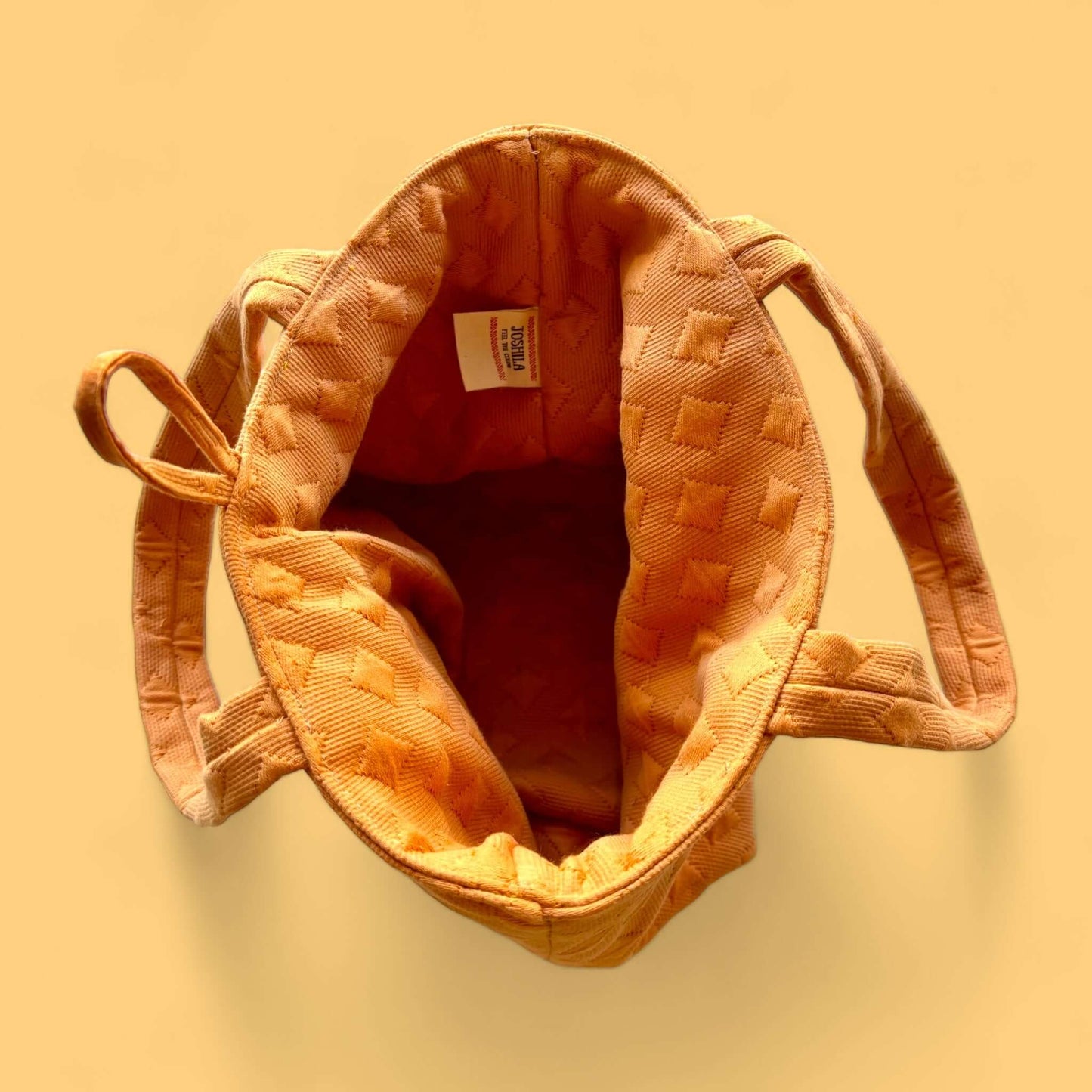 Borsa donna compatta, forma trapezio rovesciato, moda sostenibile.