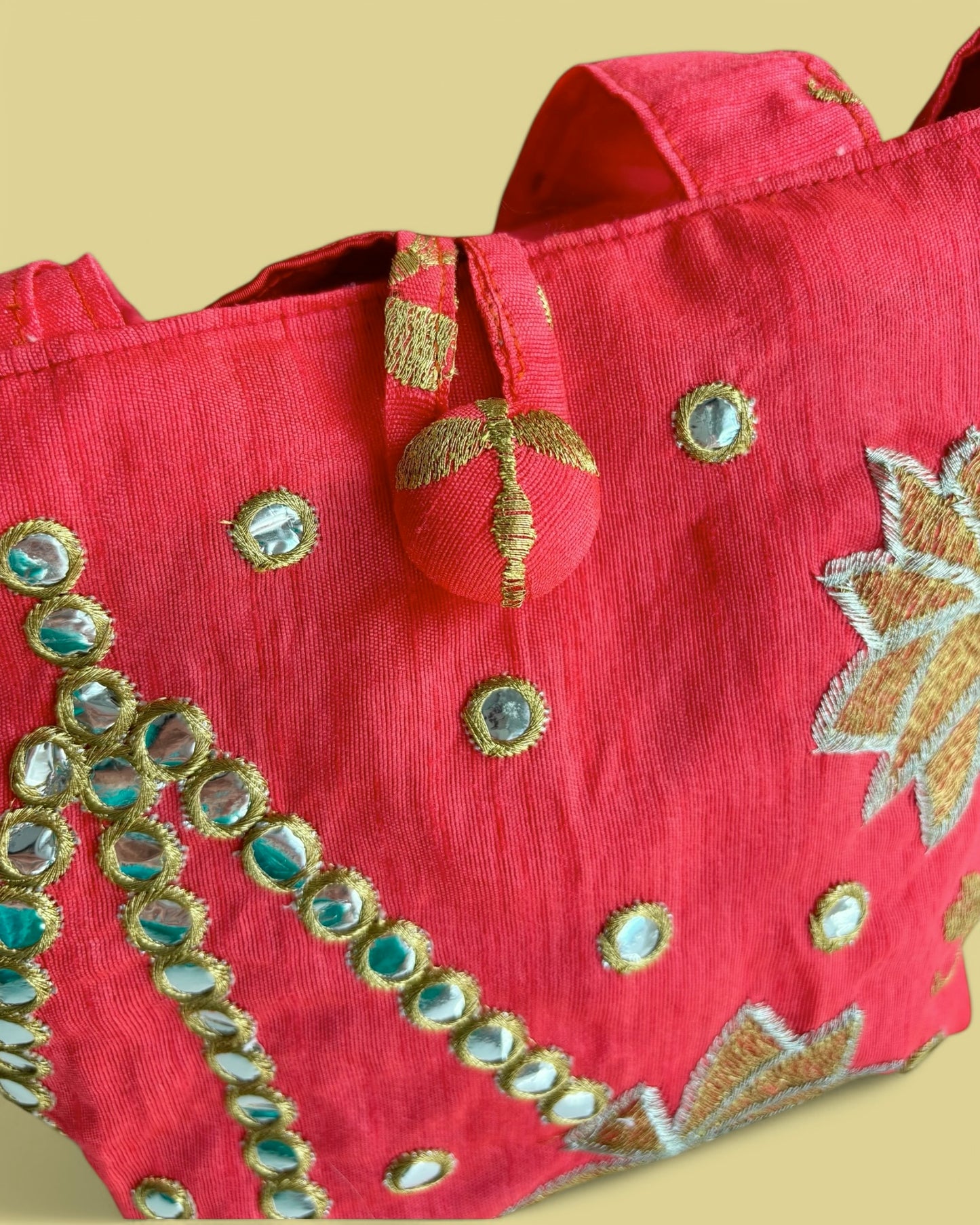 Dettaglio della chiusura con bottone rivestito della borsetta Sunita.