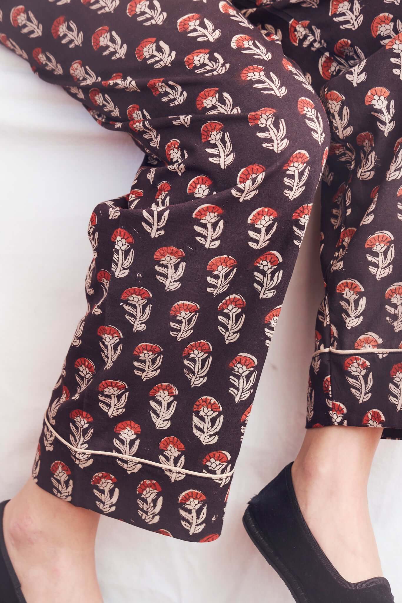 Pantalone del pigiama Giovanna con stampa floreale rossa e beige su fondo nero, elastico in vita per maggiore comfort.