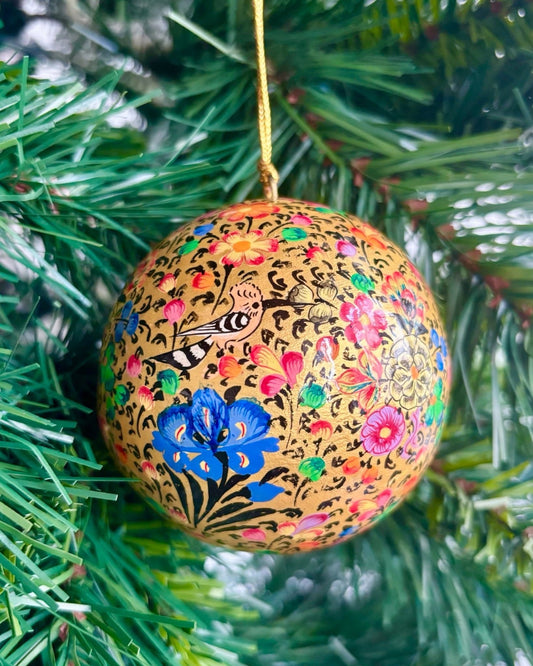 Pallina di Natale Gold apple in papier maché dipinta a mano, con fondo dorato e decorazioni raffinate di uccelli e fiori colorati. Diametro 8 cm. Realizzata artigianalmente a Srinagar, Kashmir.