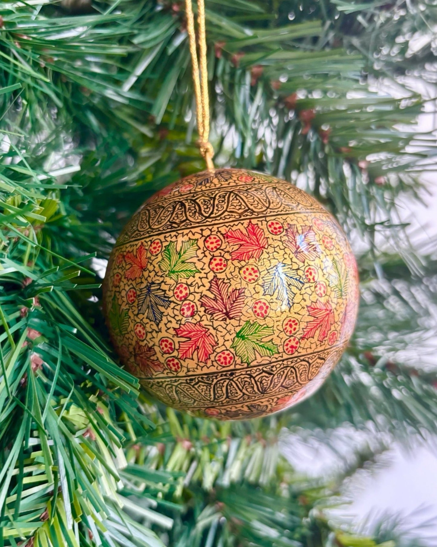 Pallina di Natale Gold maple in papier maché, dipinta a mano con eleganti foglie d'acero su fondo dorato brillante, diametro di 8 cm.