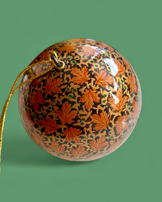 Pallina nera con foglie d’acero dorate dipinte.
