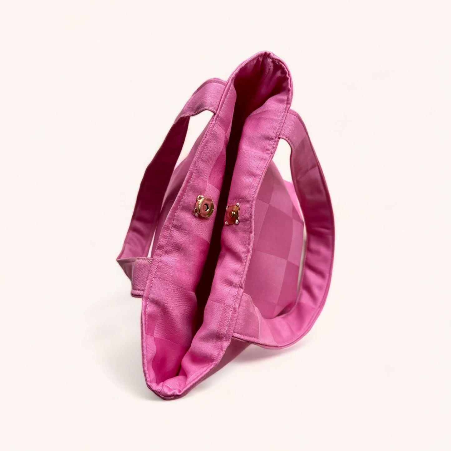 Handbag rosa compatta ed eco-friendly per transizioni giorno-sera, realizzata in cotone sostenibile con manici corti.