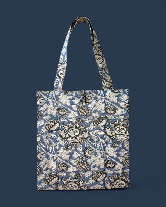 Shopper in cotone stampato a mano con tecnica blockprint, motivo floreale bianco e grigio su sfondo blu carta da zucchero, ideale per shopping e look casual.