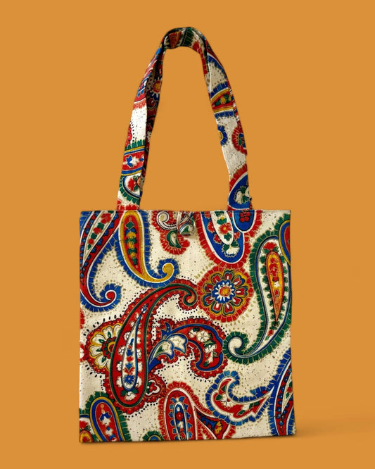 Borsa shopper artigianale multicolor in tessuto riciclato con motivo cachemire rosso, blu, verde e giallo su fondo panna, ideale per un look sostenibile e alla moda.