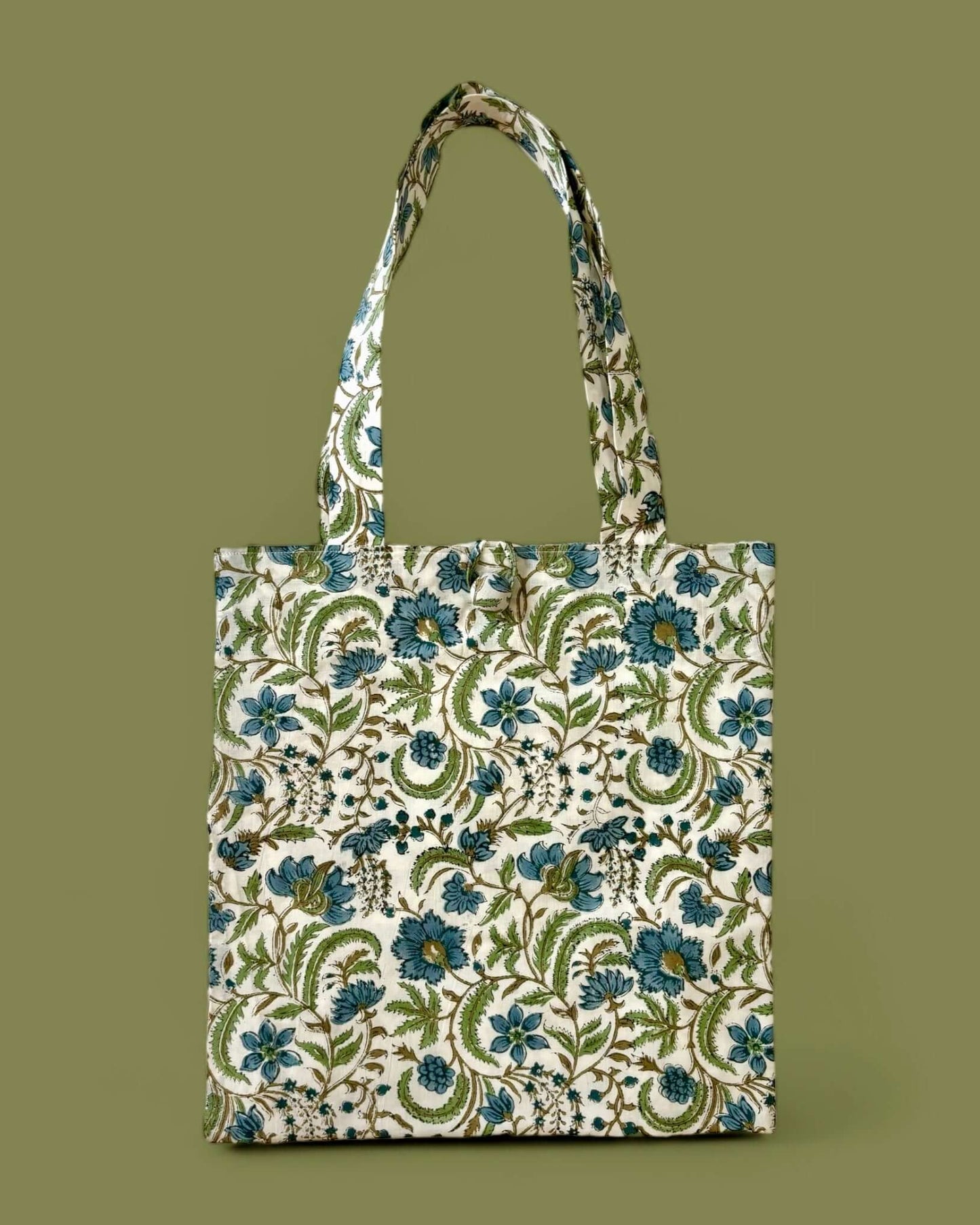 Elegante borsa in cotone con motivo floreale azzurro polvere, rami marroni e foglie verde pistacchio, ideale per un look ethnic-chic.