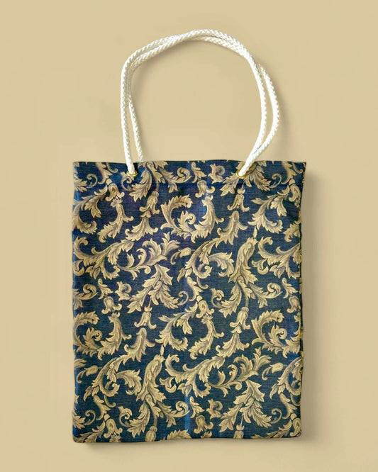 Borsa eco-friendly in cotone damascato con motivo a foglie beige su fondo blu scuro.