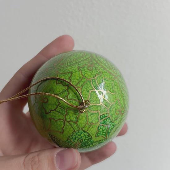 Palline di Natale in papier maché, dipinta a mano con motivi oro su fondo verde mela.