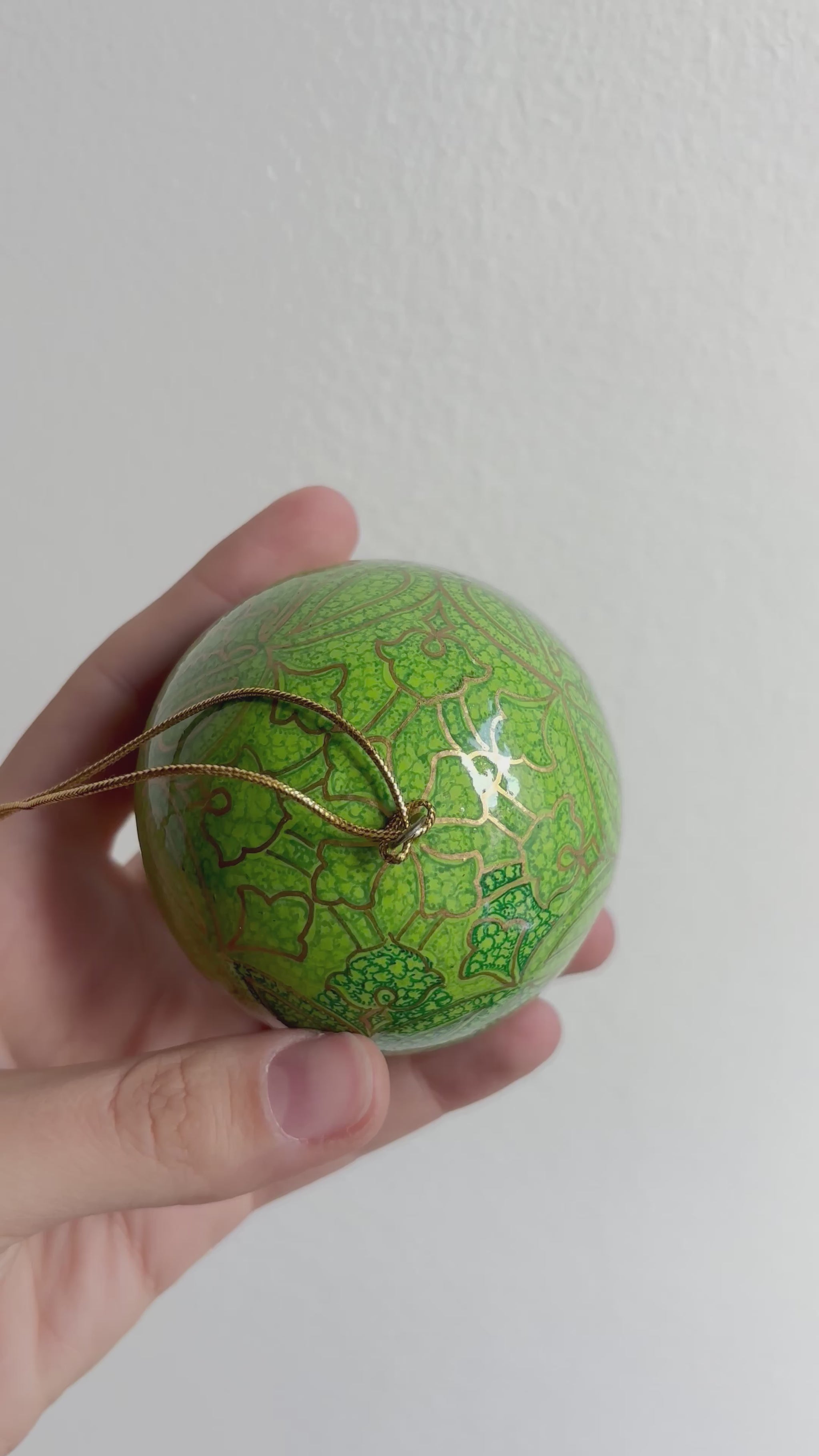 Palline di Natale in papier maché, dipinta a mano con motivi oro su fondo verde mela.